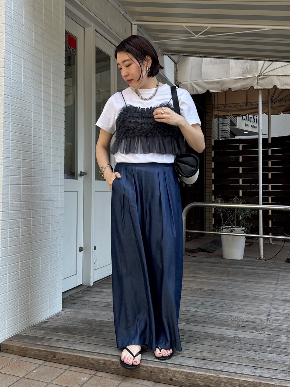 ブルー系のデニムパンツ、ホワイト系のTシャツ/カットソー、グレー系のキャミソールを着用したレディースの夏コーディネートの5枚目の写真