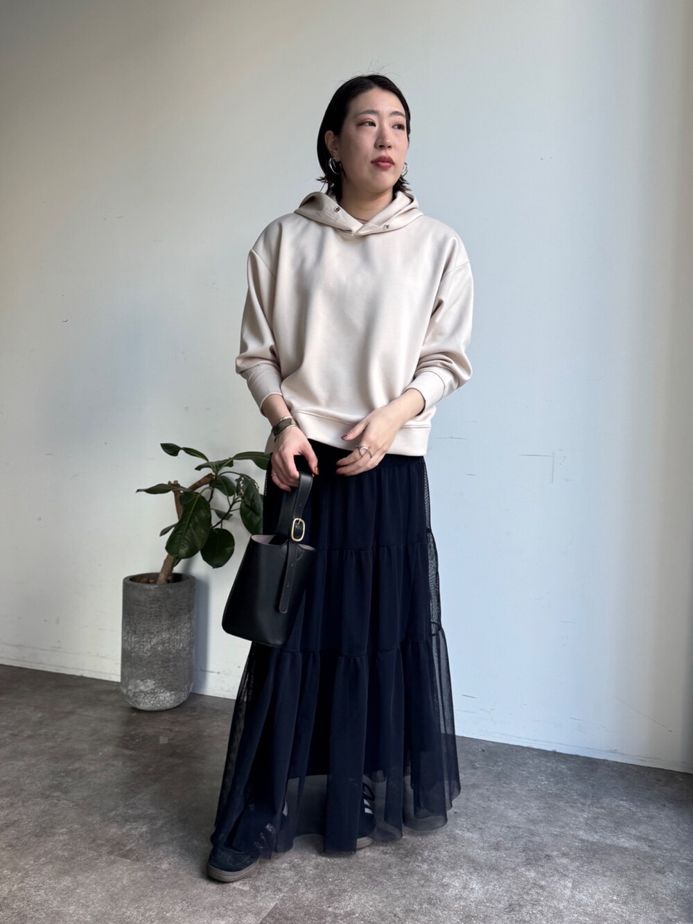 ホワイト系のセットアップ、ブルー系のスカートを着用したレディースの冬コーディネートの2枚目の写真