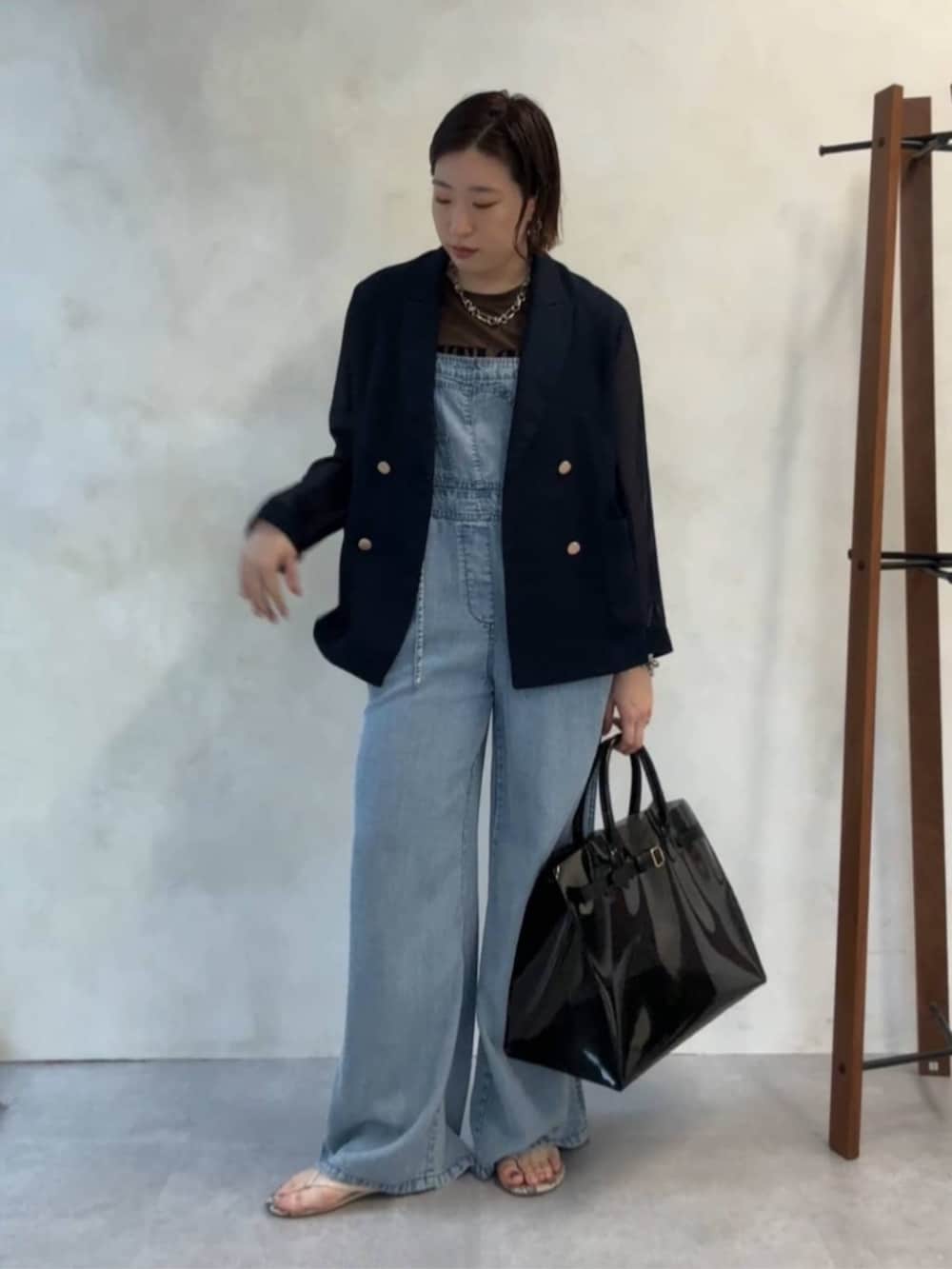 ブルー系のテーラードジャケット、ブラック系のショルダーバッグ、ブルー系のつなぎ/オールインワンを着用したレディースの夏コーディネートの8枚目の写真