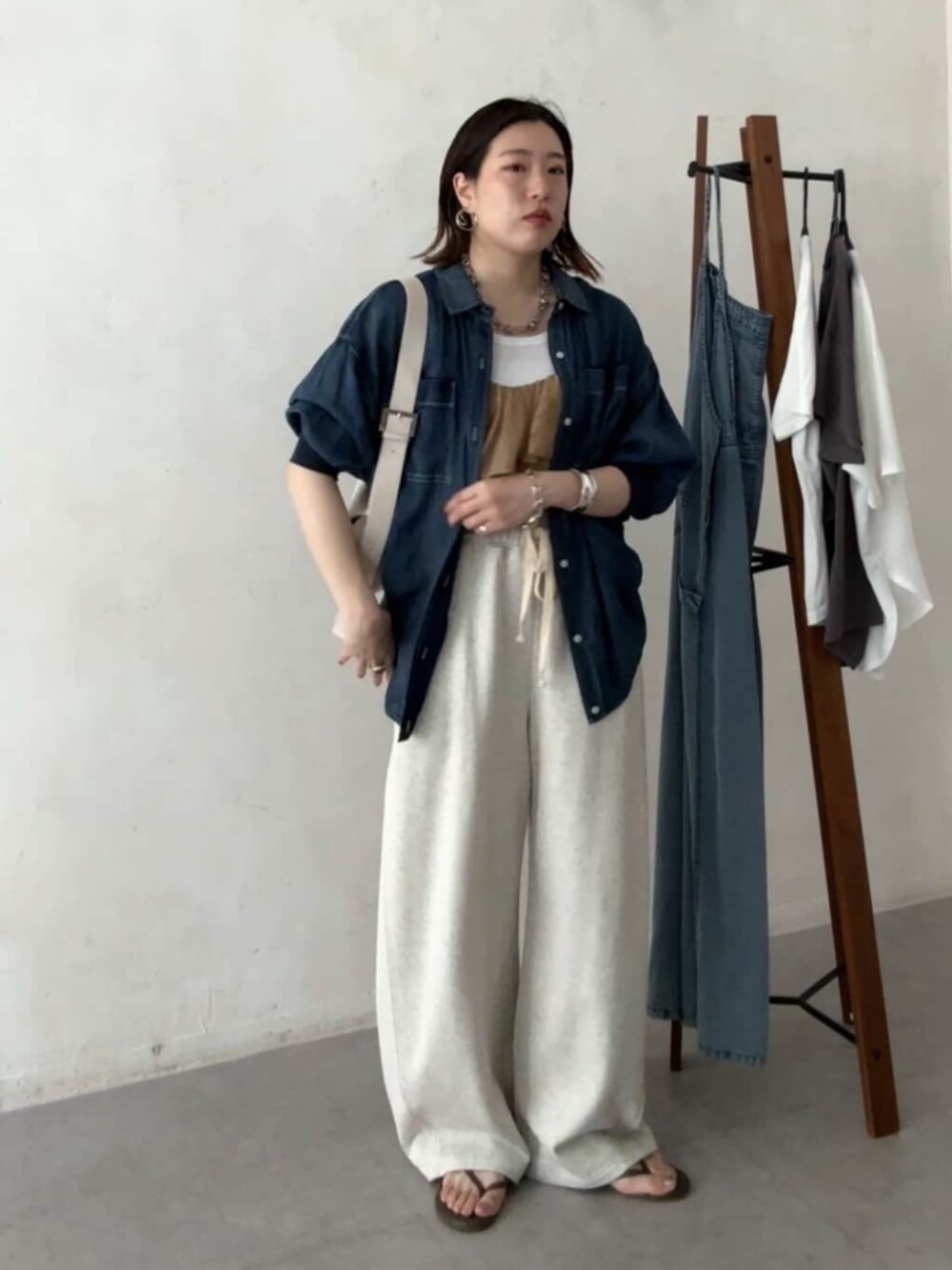 ホワイト系のショルダーバッグ、ベージュ系のその他パンツ、ブルー系のシャツ/ブラウスを着用したレディースの春コーディネートの6枚目の写真