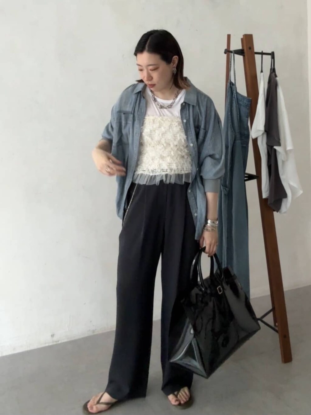 ブラック系のショルダーバッグ、ブルー系のシャツ/ブラウス、グレー系のその他パンツを着用したレディースの夏コーディネートの2枚目の写真