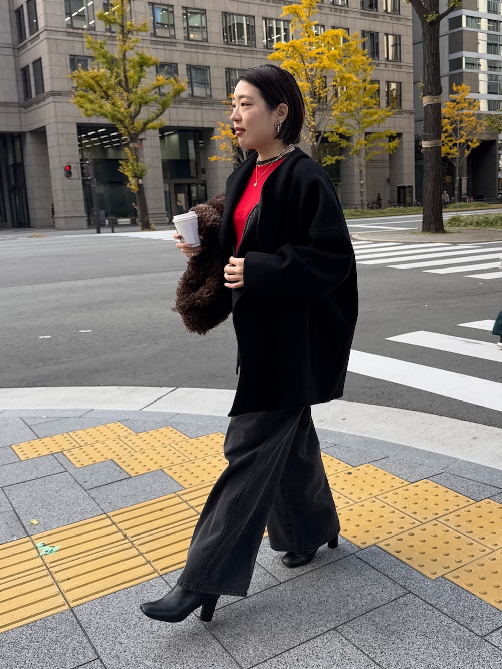 ブラック系のつなぎ/オールインワン、レッド系のニット/セーター、ブラック系のその他アウターを着用したレディースの冬コーディネートの3枚目の写真