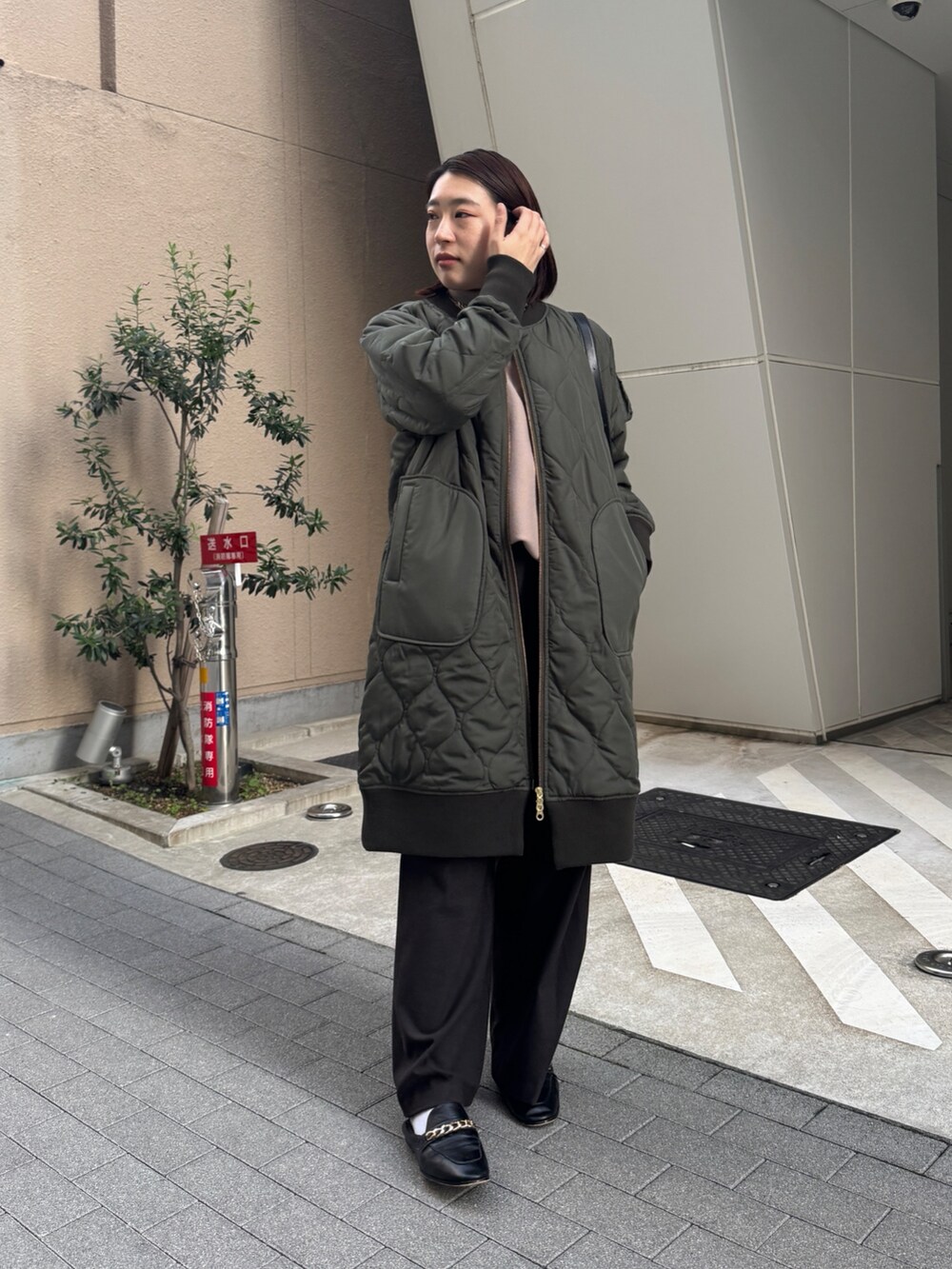 グリーン系のその他アウター、ベージュ系のニット/セーター、ブラウン系のその他パンツを着用したレディースの冬コーディネートの2枚目の写真