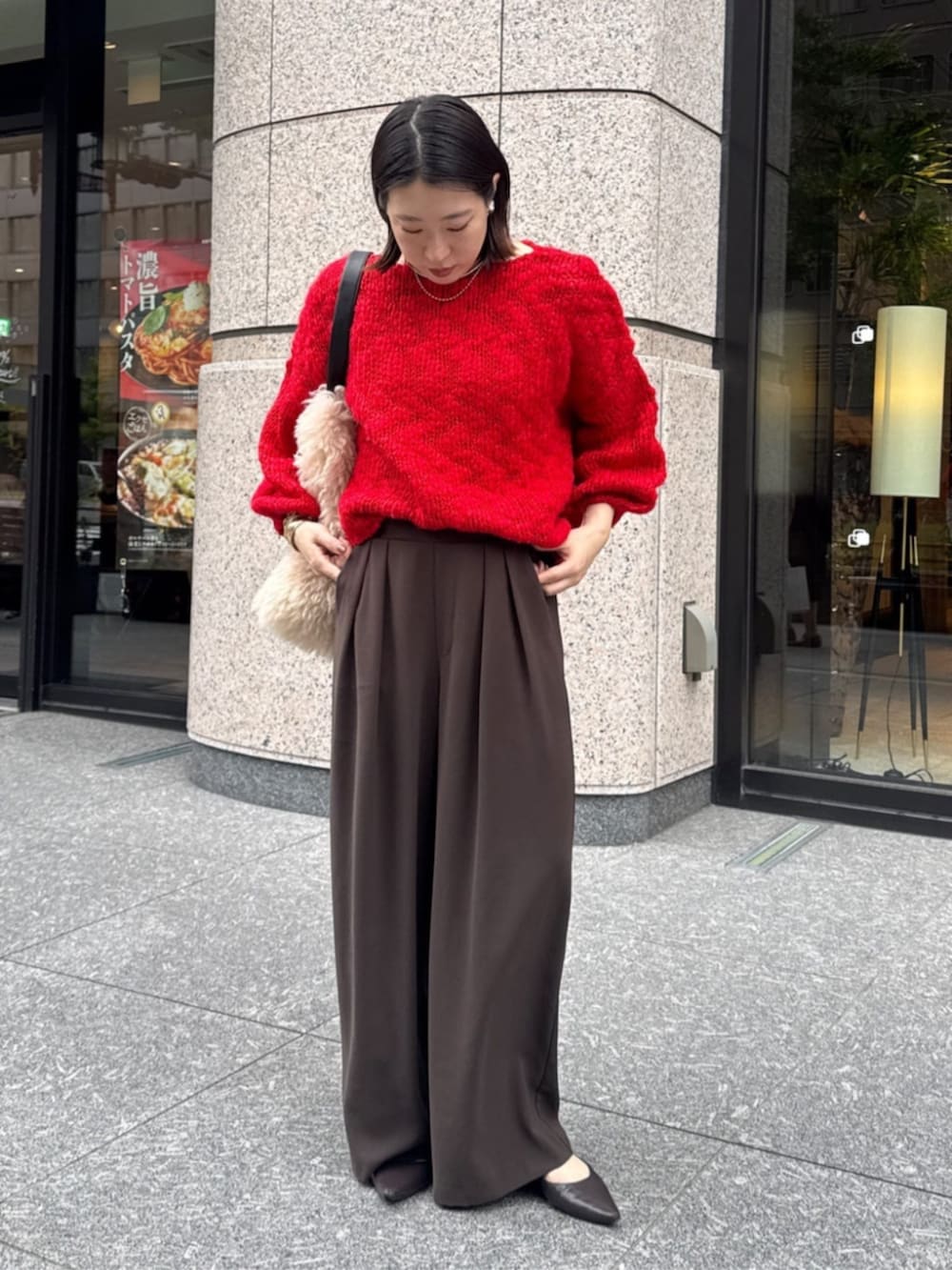 ブラウン系のスラックス、ホワイト系のショルダーバッグ、レッド系のニット/セーターを着用したレディースの秋コーディネートの3枚目の写真