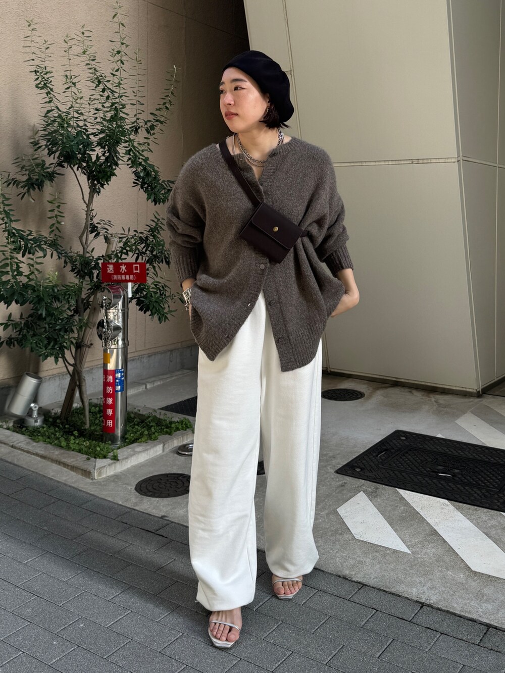 ホワイト系のスウェットパンツ、ベージュ系のニット/セーター、ブラウン系のショルダーバッグを着用したレディースの夏コーディネートの2枚目の写真