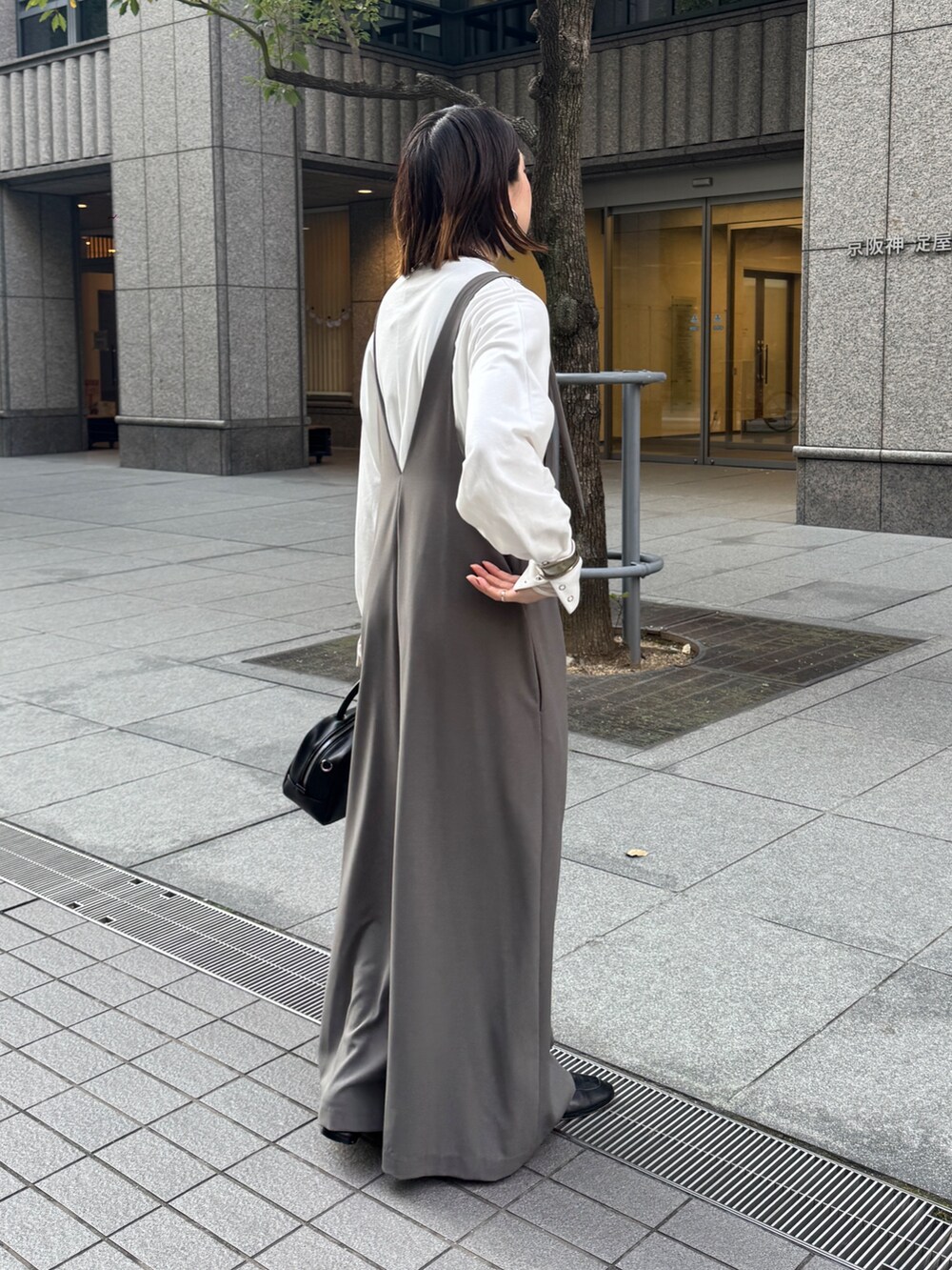 グレー系のつなぎ/オールインワン、ホワイト系のTシャツ/カットソー、シルバー系のネックレスを着用したレディースの冬コーディネートの6枚目の写真