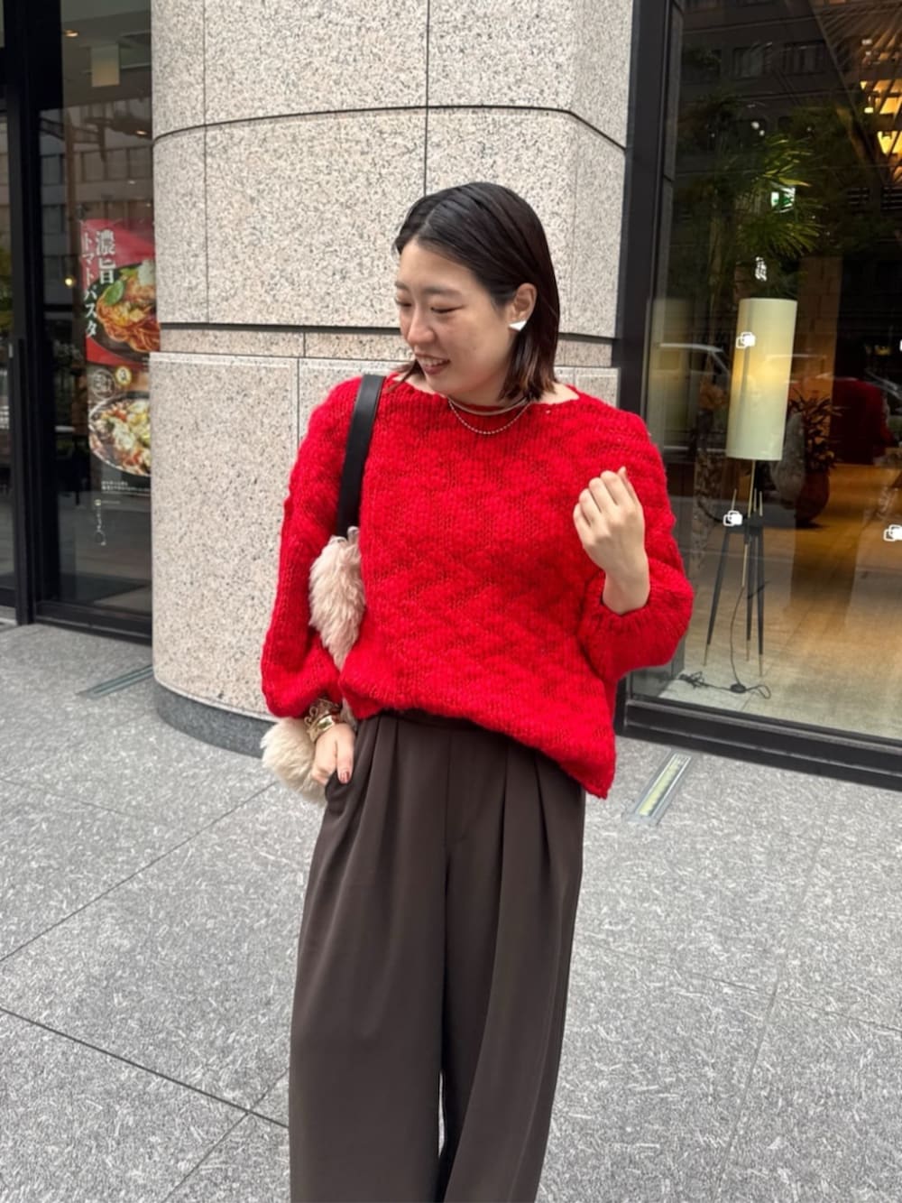 ブラウン系のスラックス、ホワイト系のショルダーバッグ、レッド系のニット/セーターを着用したレディースの秋コーディネートの6枚目の写真