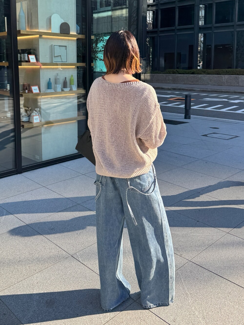 ベージュ系のニット/セーター、ブルー系のデニムパンツ、ブラウン系のTシャツ/カットソーを着用したレディースの冬コーディネートの6枚目の写真