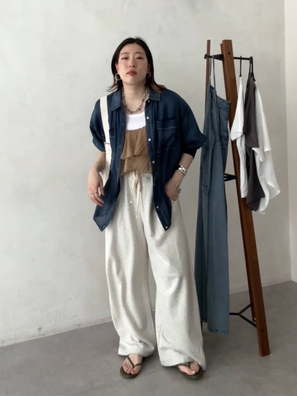 ホワイト系のショルダーバッグ、ベージュ系のその他パンツ、ブルー系のシャツ/ブラウスを着用したレディースの春コーディネートの5枚目の写真