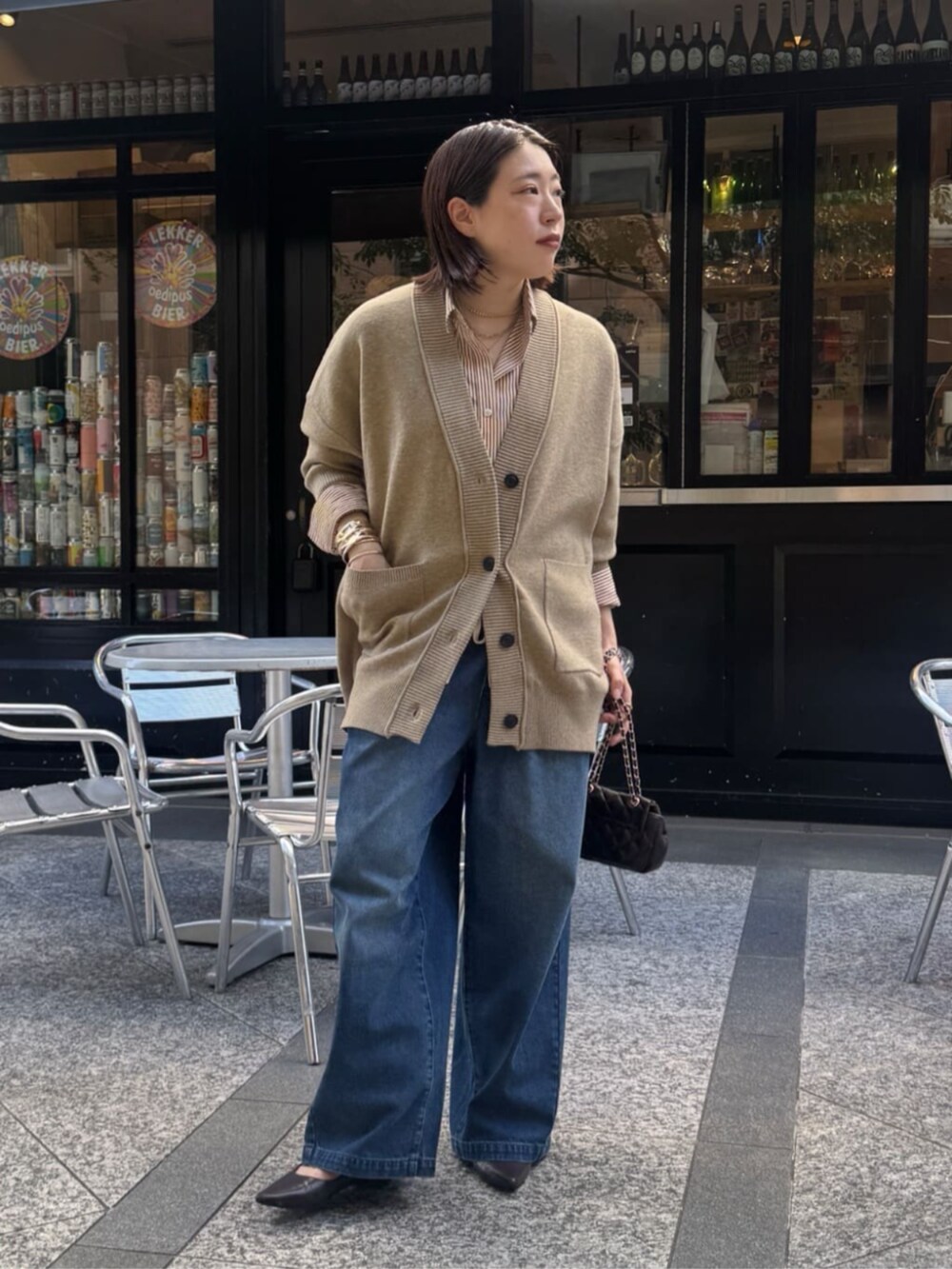 ブラウン系のショルダーバッグ、ブラウン系のシャツ/ブラウス、ブラウン系のパンプスを着用したレディースの秋コーディネートの2枚目の写真