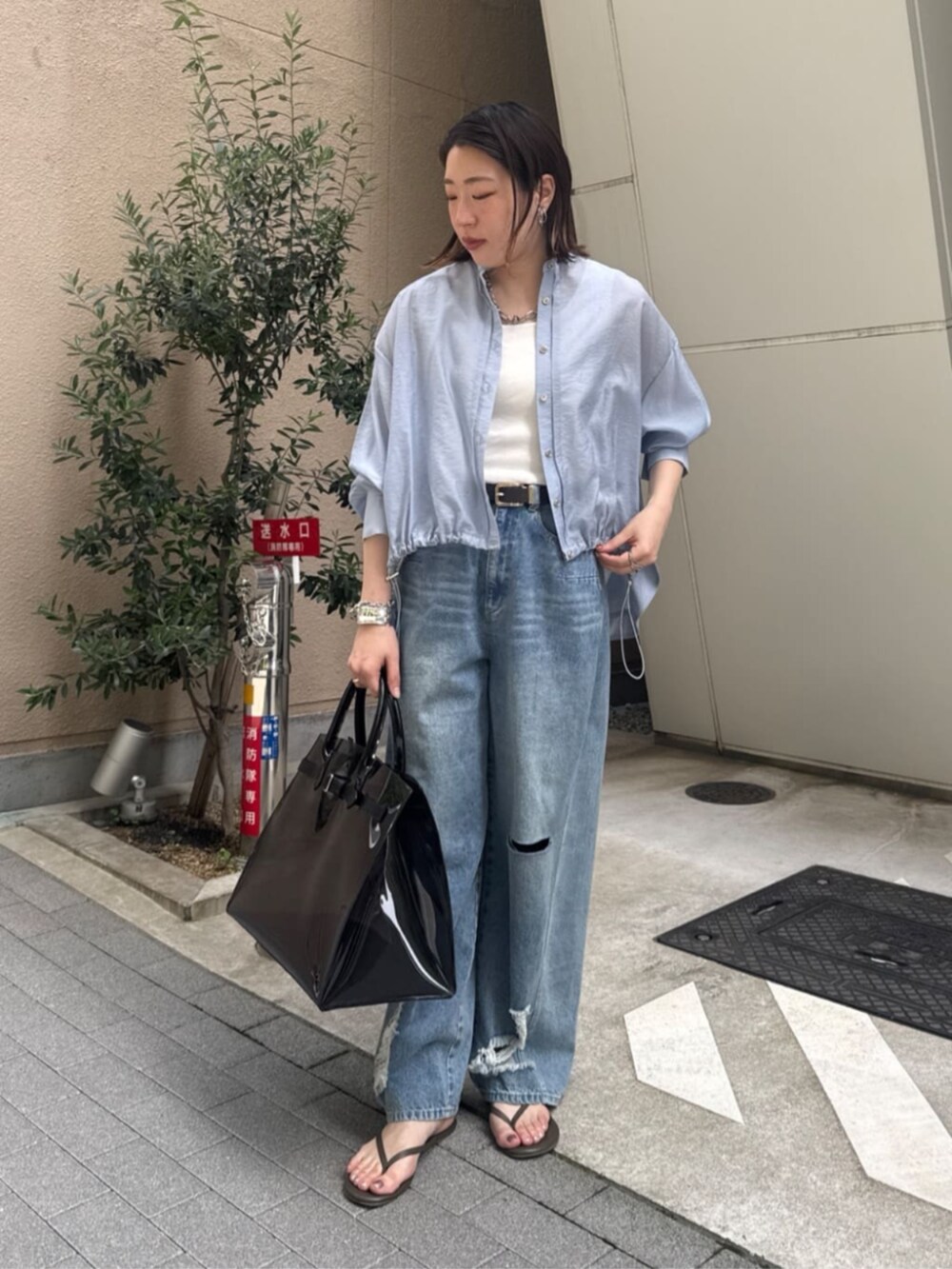 ホワイト系のタンクトップ、ブラック系のショルダーバッグ、ブルー系のデニムパンツを着用したレディースの春コーディネートの7枚目の写真