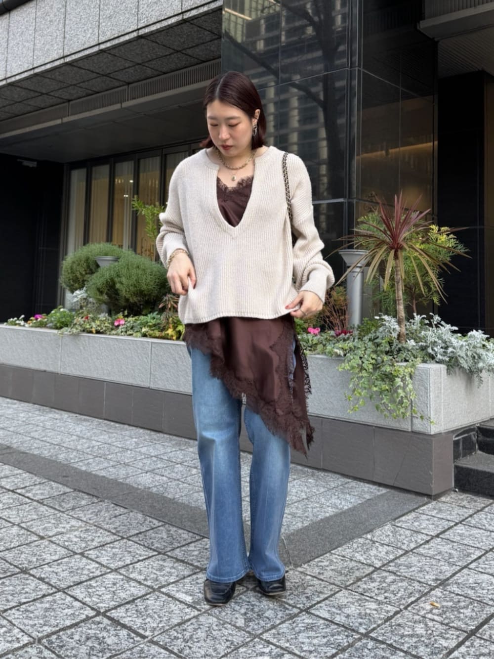 ブラウン系のキャミソール、ブルー系のデニムパンツ、ホワイト系のニット/セーターを着用したレディースの冬コーディネートの7枚目の写真