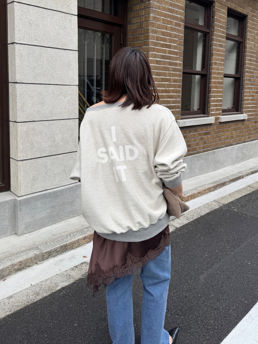 グレー系のTシャツ/カットソー、ブラウン系のキャミソール、ブルー系のデニムパンツを着用したレディースの冬コーディネートの4枚目の写真