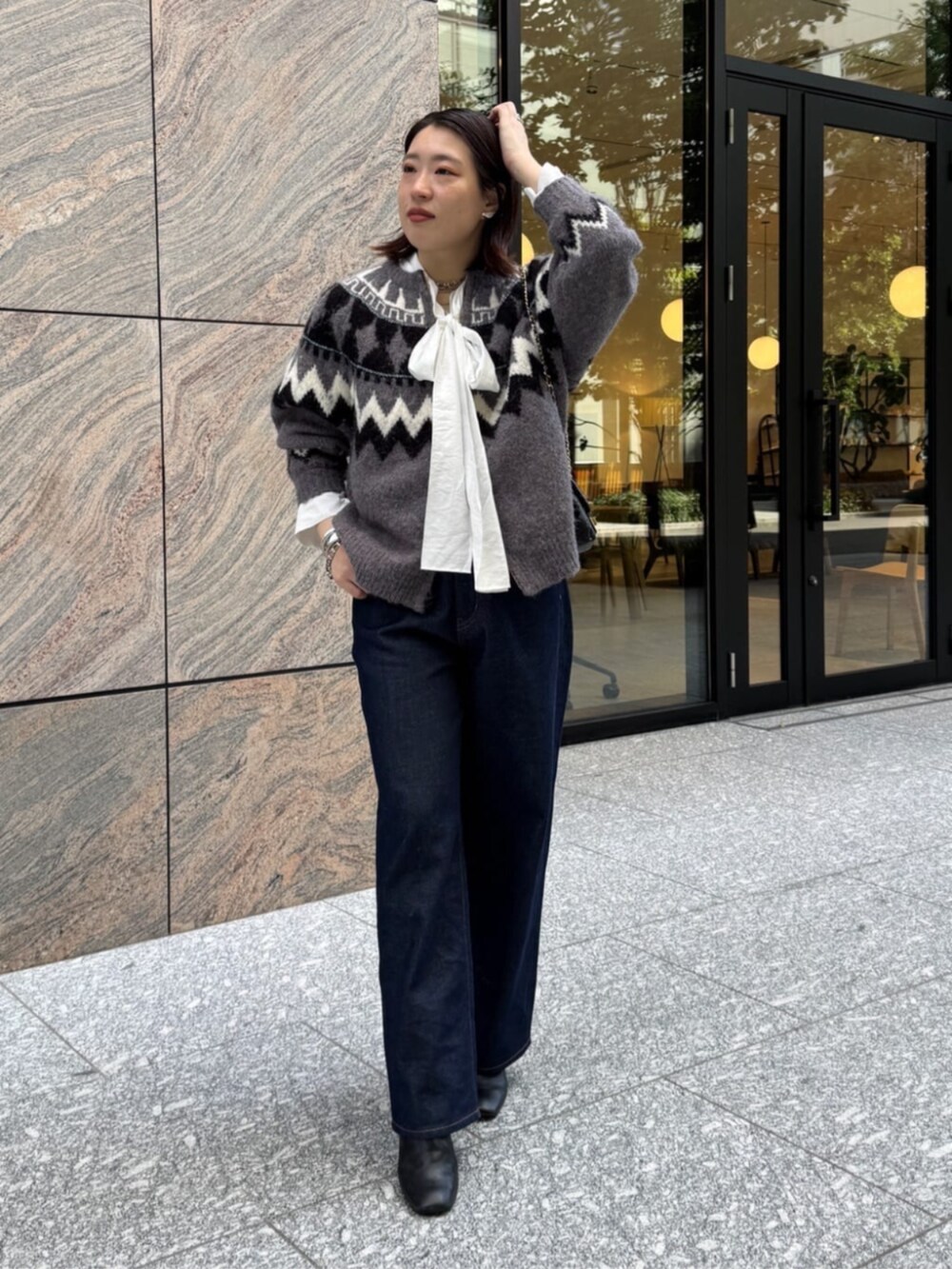 ブラック系のショルダーバッグ、ブルー系のデニムパンツ、ホワイト系のシャツ/ブラウスを着用したレディースの秋コーディネートの4枚目の写真