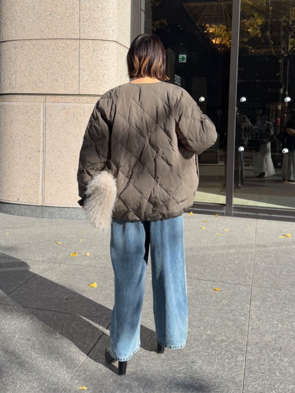 ホワイト系のショルダーバッグ、ブルー系のデニムパンツ、グレー系のその他アウターを着用したレディースの冬コーディネートの7枚目の写真