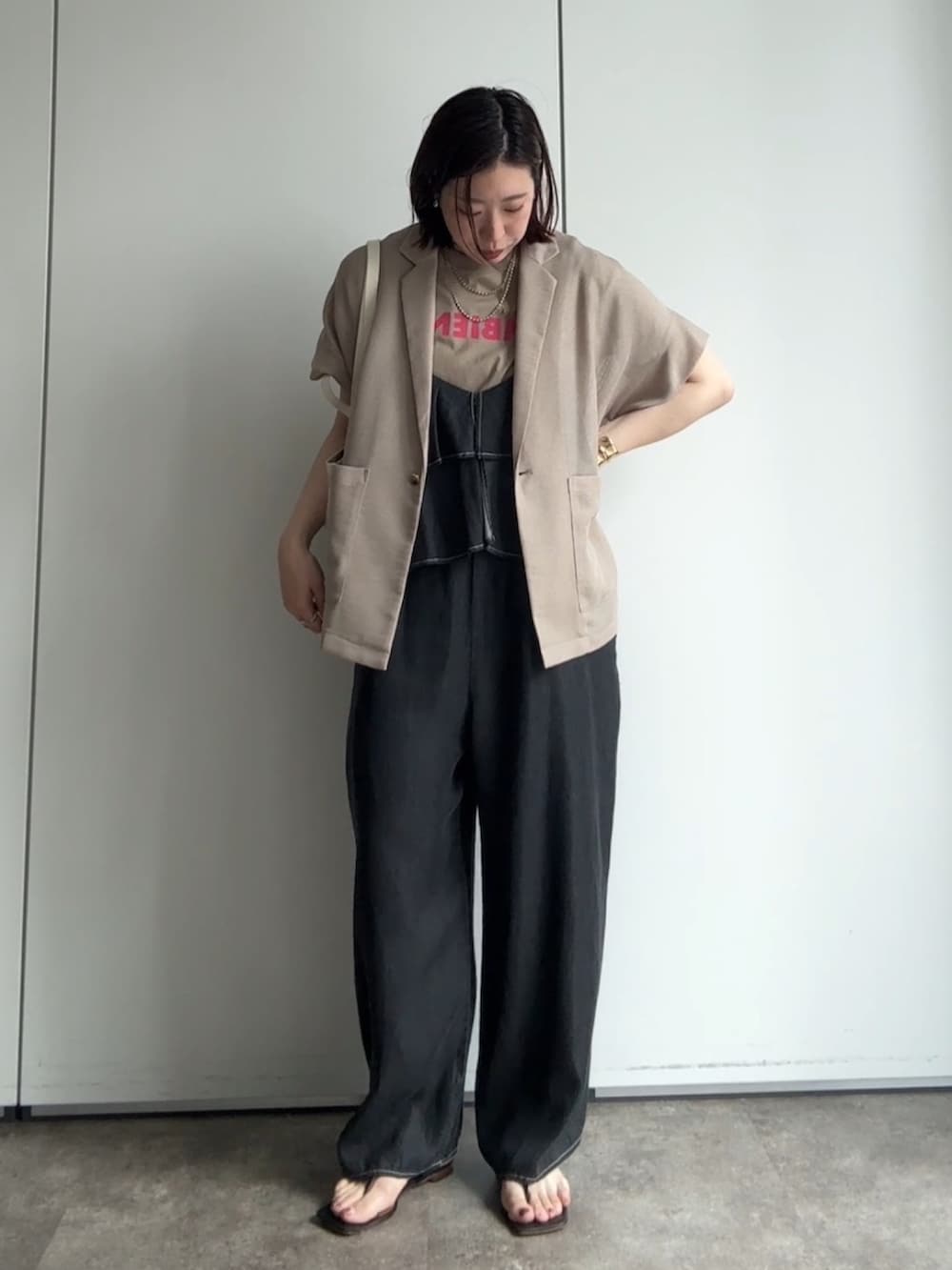 ベージュ系のテーラードジャケット、ベージュ系のTシャツ/カットソー、ブラック系のつなぎ/オールインワンを着用したレディースの夏コーディネートの5枚目の写真