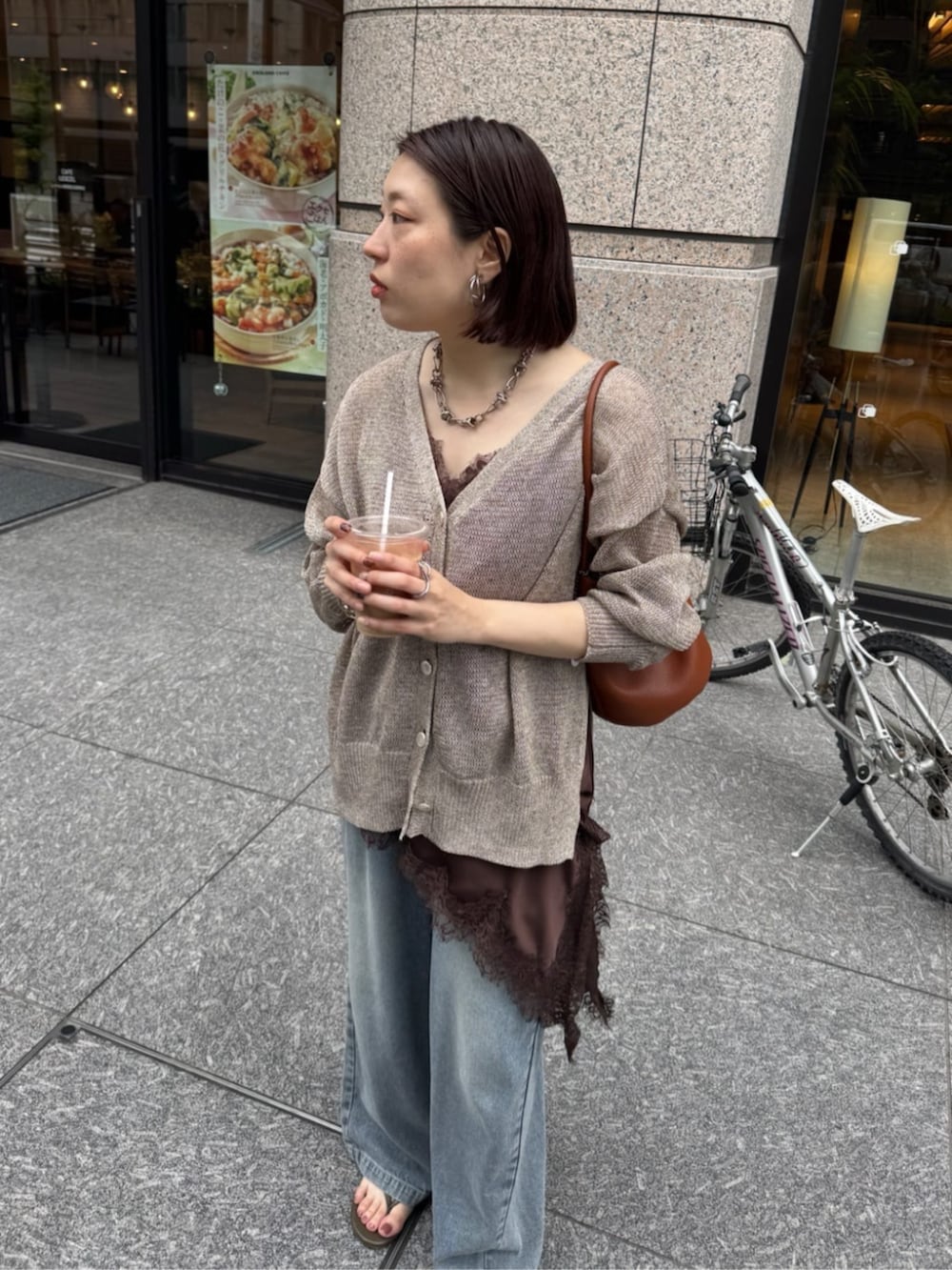 ブルー系のデニムパンツ、ブラウン系のキャミソール、ベージュ系のカーディガン/ボレロを着用したレディースの春コーディネートの7枚目の写真