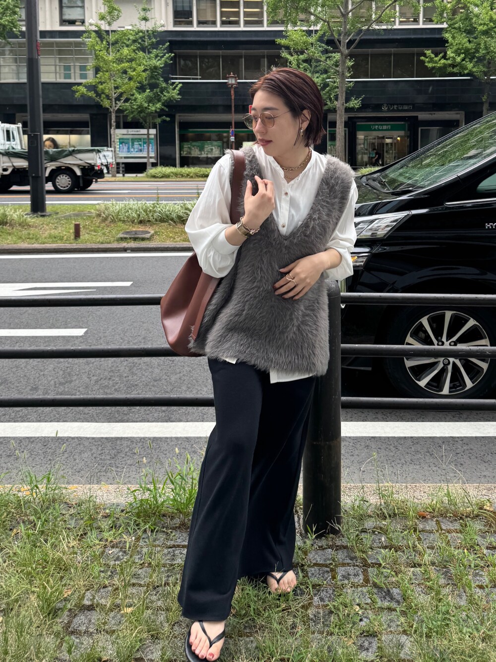 グレー系のニット/セーター、ブラック系のその他パンツ、ブラウン系のショルダーバッグを着用したレディースの夏コーディネートの3枚目の写真