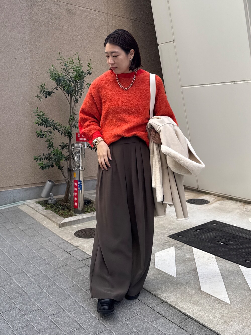 ブラウン系のスラックス、ホワイト系のその他アウター、ホワイト系のショルダーバッグを着用したレディースの秋コーディネートの8枚目の写真