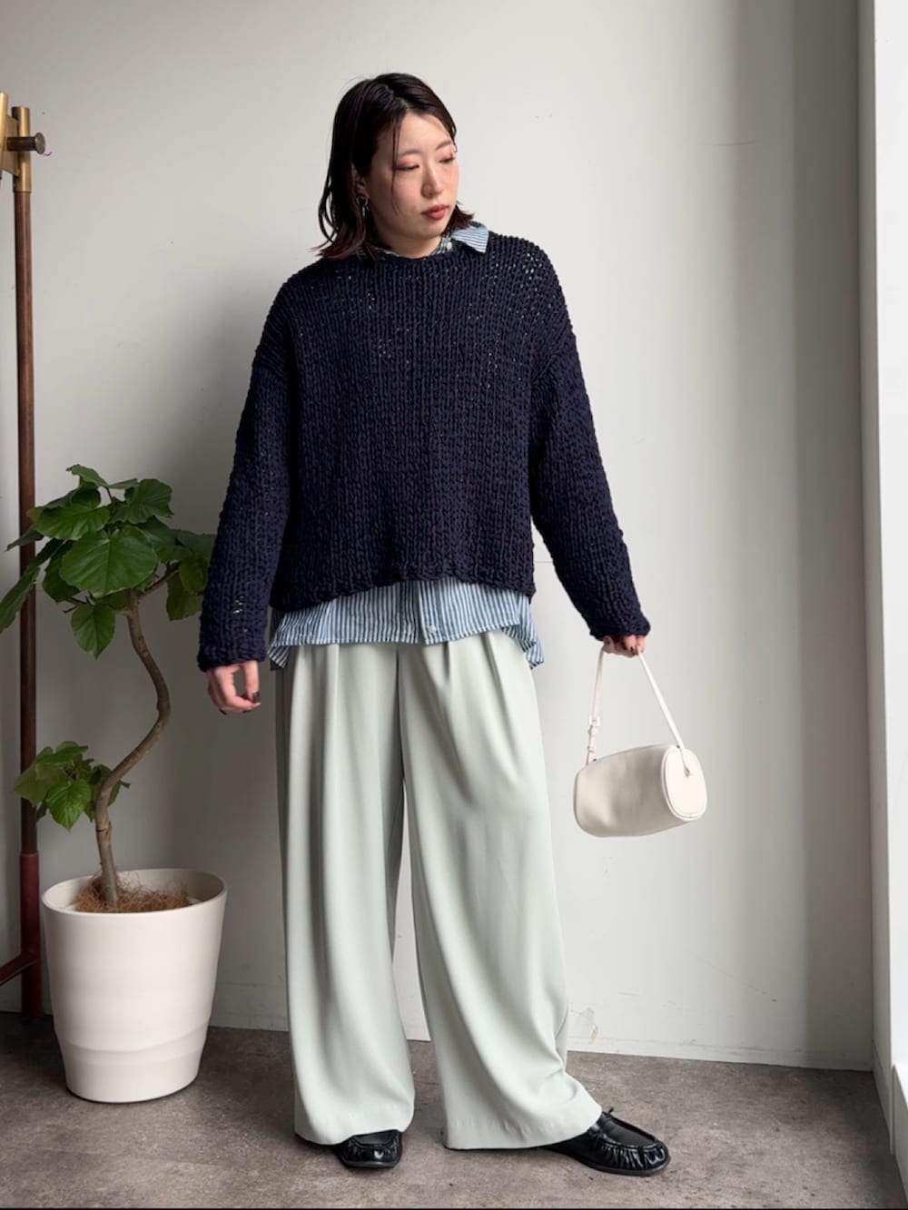 ブルー系のニット/セーター、ブルー系のシャツ/ブラウス、グリーン系のスラックスを着用したレディースの冬コーディネートの2枚目の写真