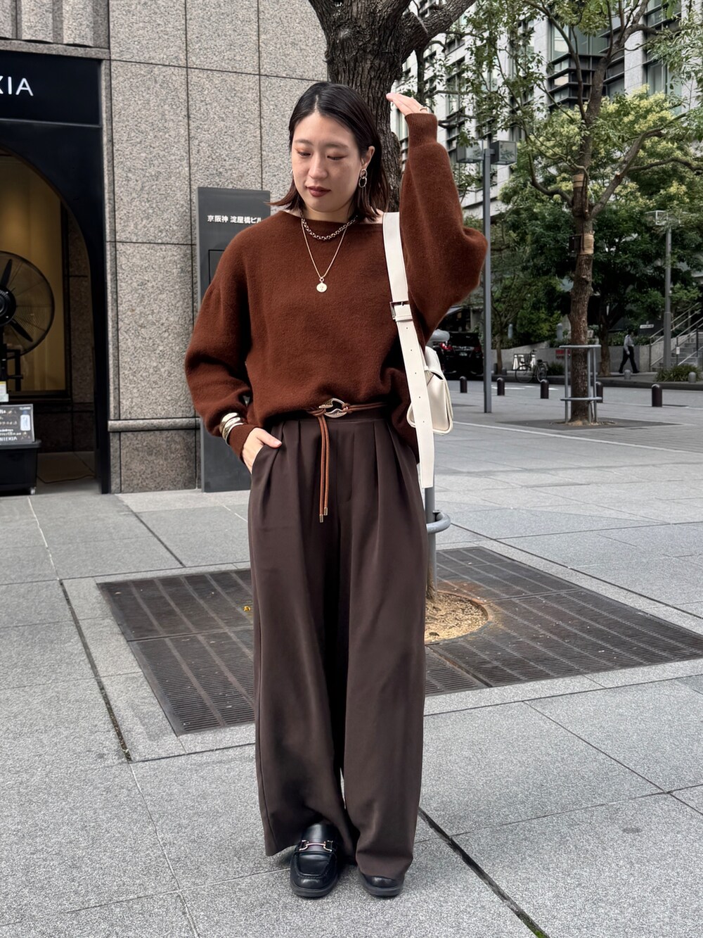 ブラウン系のニット/セーター、ブラウン系のスラックス、ブラウン系のベルトを着用したレディースの秋コーディネートの3枚目の写真
