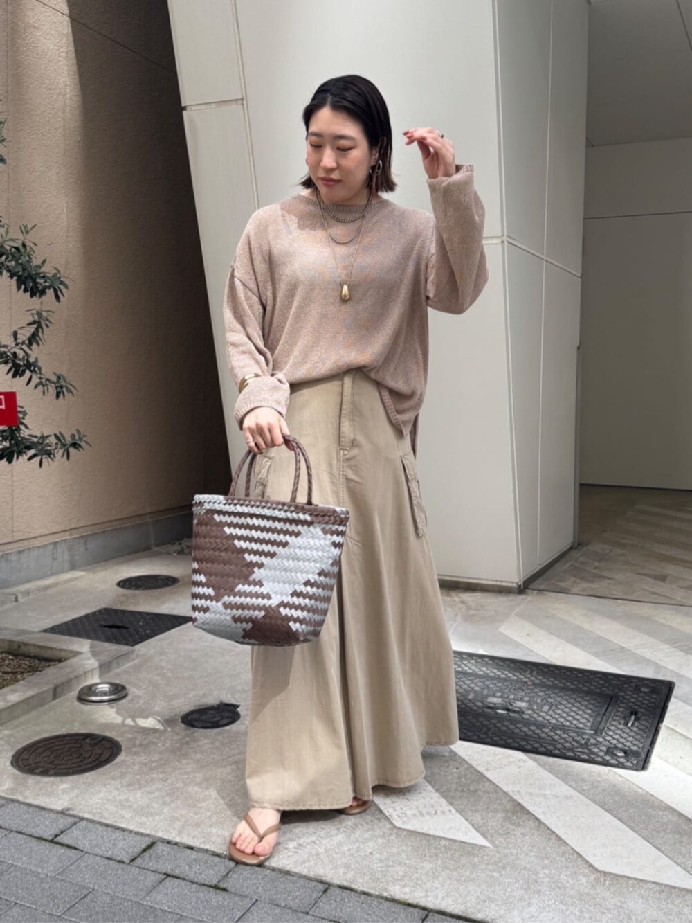 ベージュ系のスカート、ゴールド系のネックレスを着用したレディースの春コーディネートの5枚目の写真