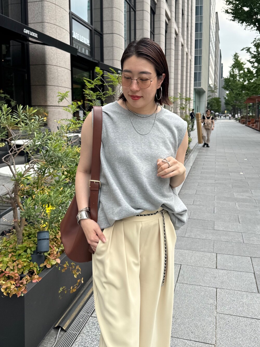 イエロー系のスラックス、グレー系のスウェット、シルバー系のベルトを着用したレディースの夏コーディネートの8枚目の写真