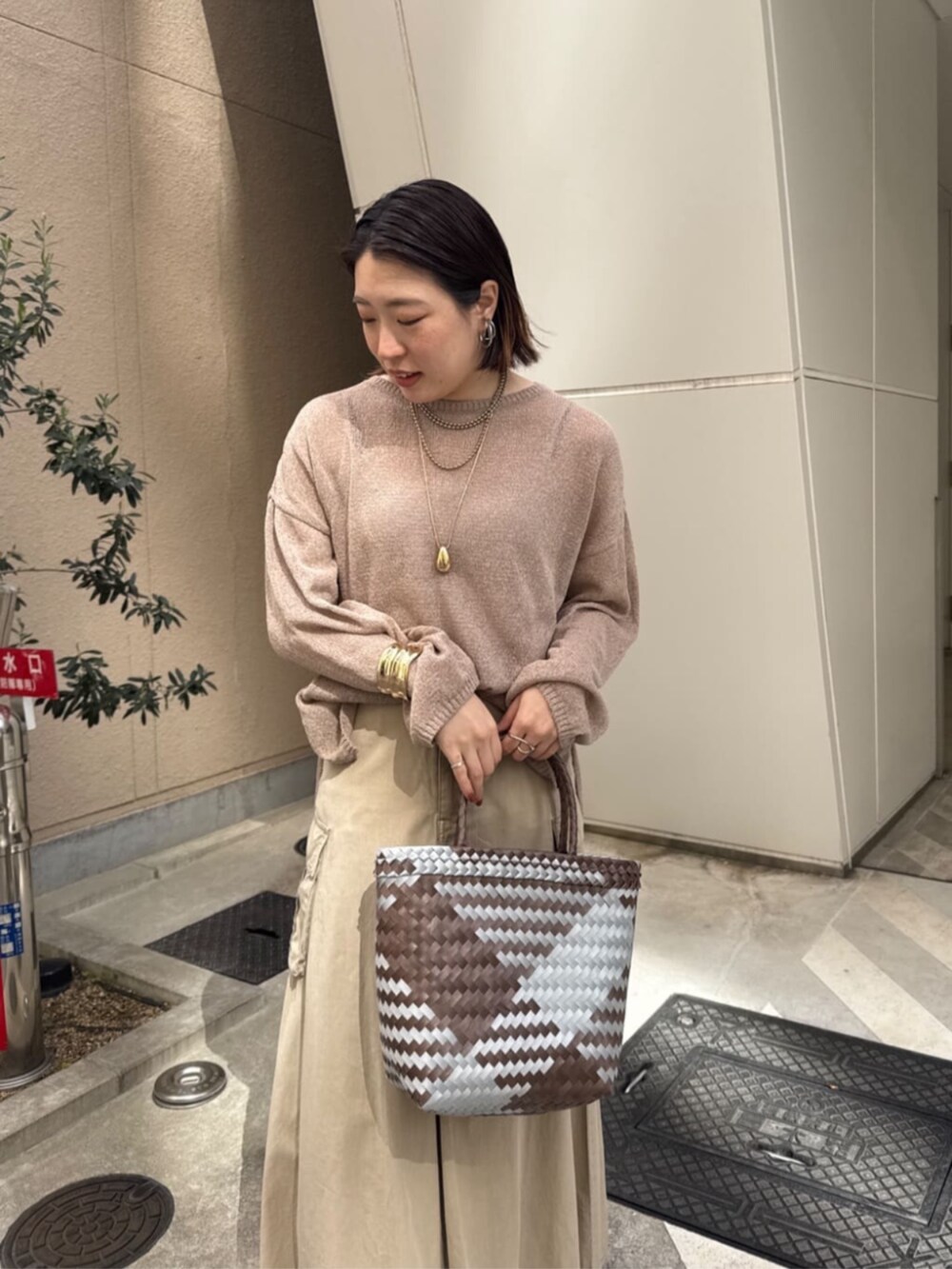 ベージュ系のスカート、ゴールド系のネックレスを着用したレディースの春コーディネートの8枚目の写真