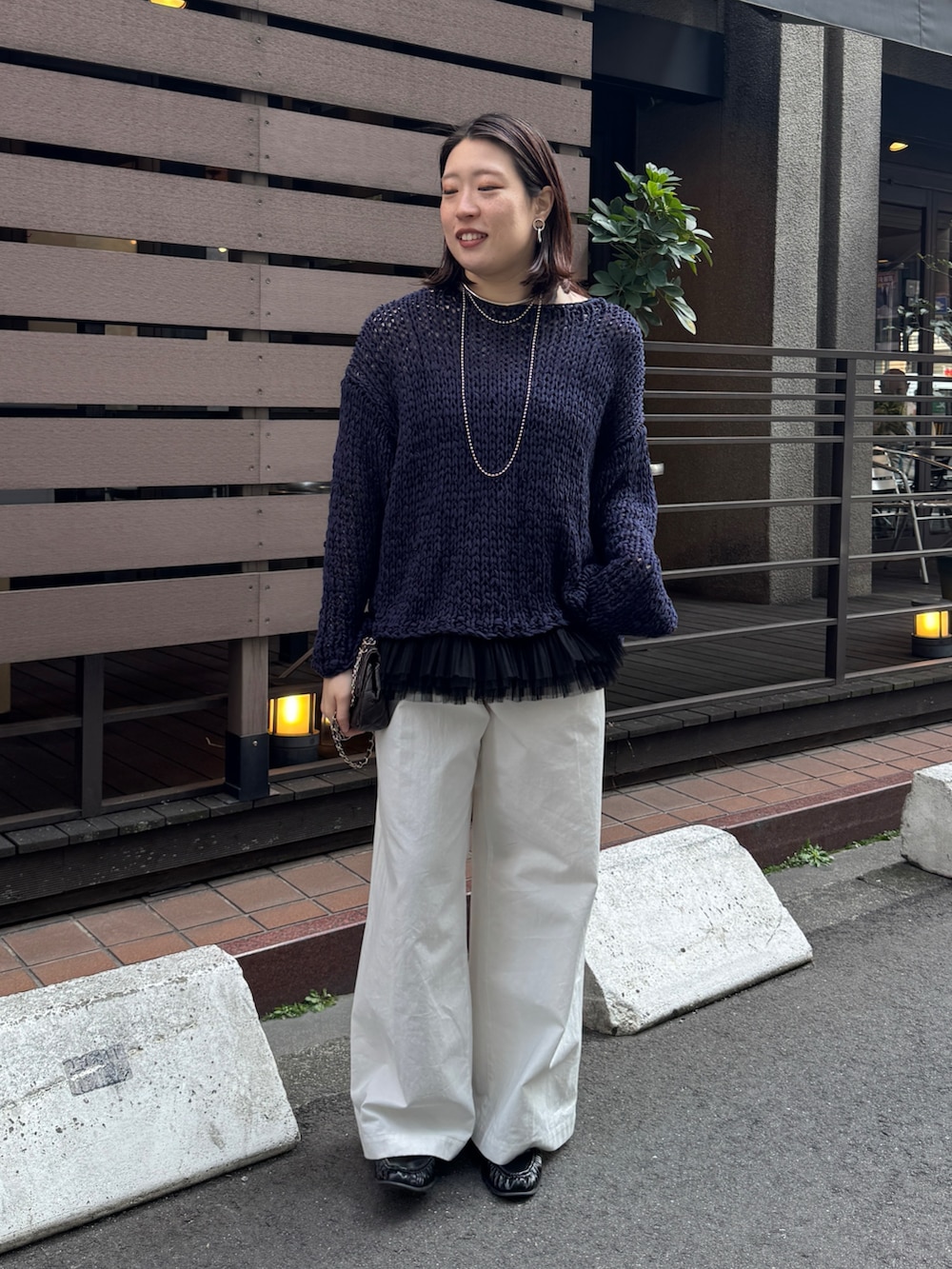 ブルー系のニット/セーター、ブラック系のシャツ/ブラウス、ホワイト系のその他パンツを着用したレディースの春コーディネートの5枚目の写真