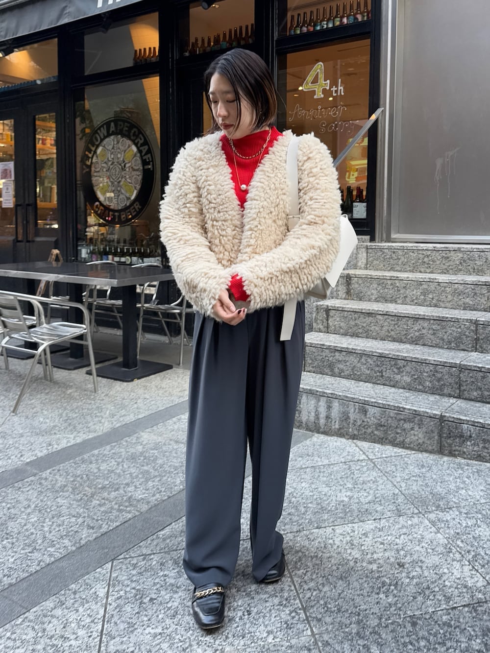 グレー系のスラックス、ホワイト系のショルダーバッグ、ベージュ系のカーディガン/ボレロを着用したレディースの冬コーディネートの5枚目の写真