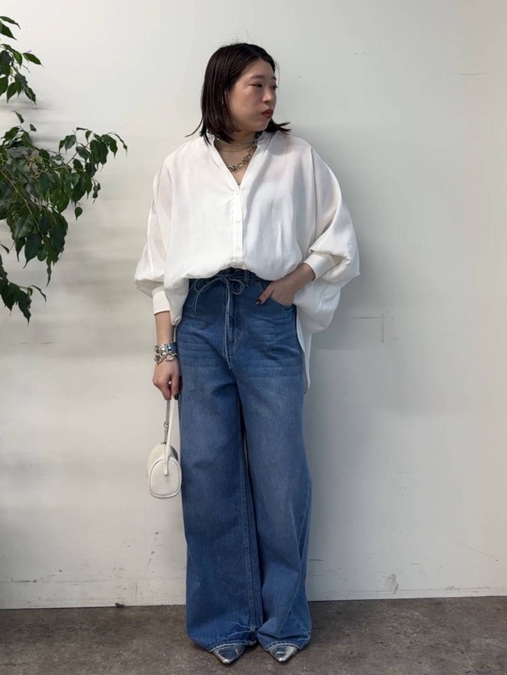 ホワイト系のシャツ/ブラウス、ブルー系のデニムパンツを着用したレディースの冬コーディネートの4枚目の写真