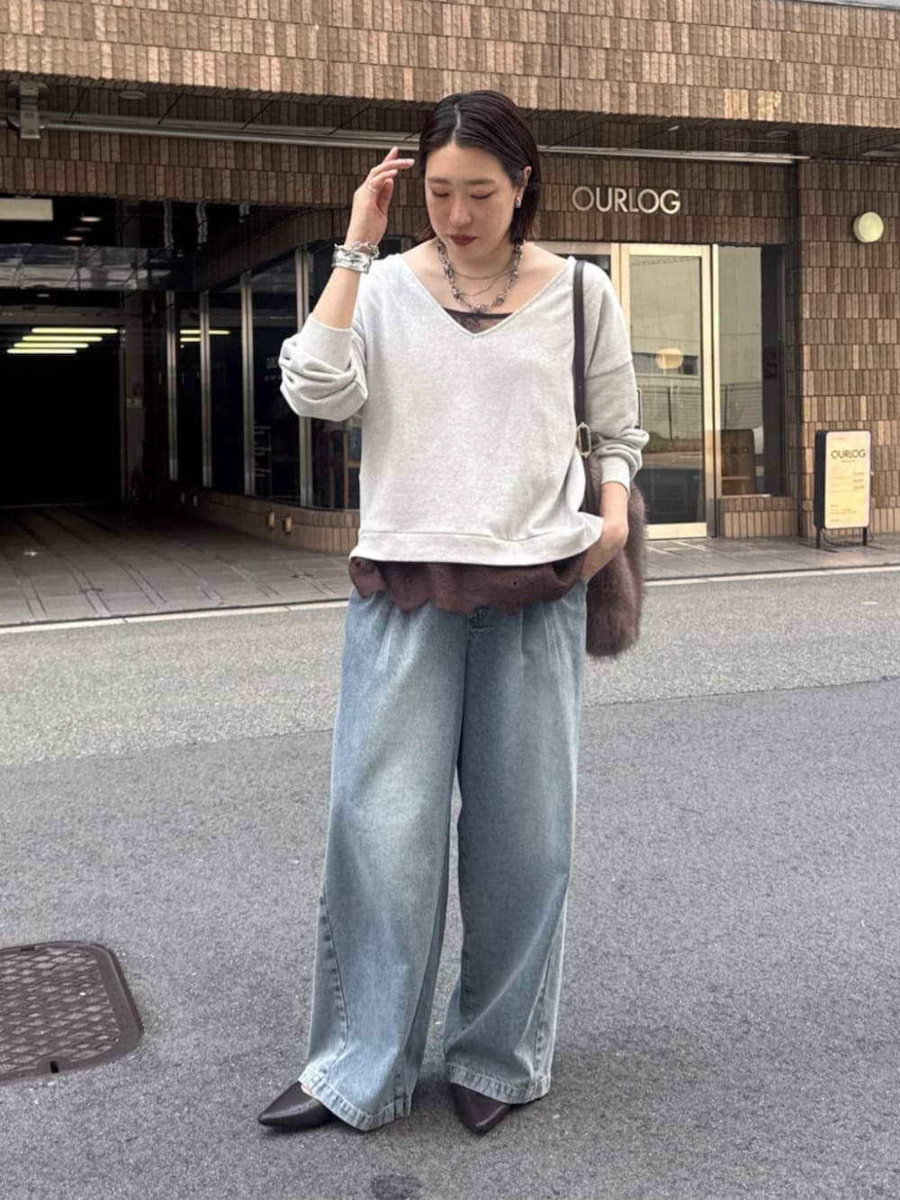 ブルー系のデニムパンツ、ブラウン系のパンプス、ブラウン系のシャツ/ブラウスを着用したレディースの夏コーディネートの4枚目の写真