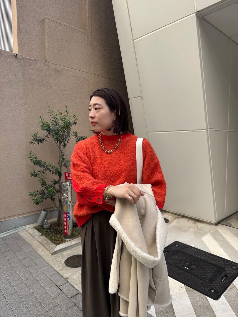 ブラウン系のスラックス、ホワイト系のその他アウター、ホワイト系のショルダーバッグを着用したレディースの秋コーディネートの5枚目の写真