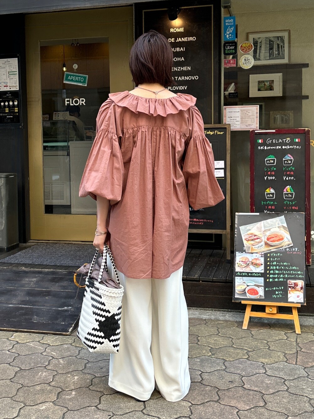 ホワイト系のスラックス、ブラウン系のシャツ/ブラウス、ホワイト系のかごバッグを着用したレディースの夏コーディネートの5枚目の写真