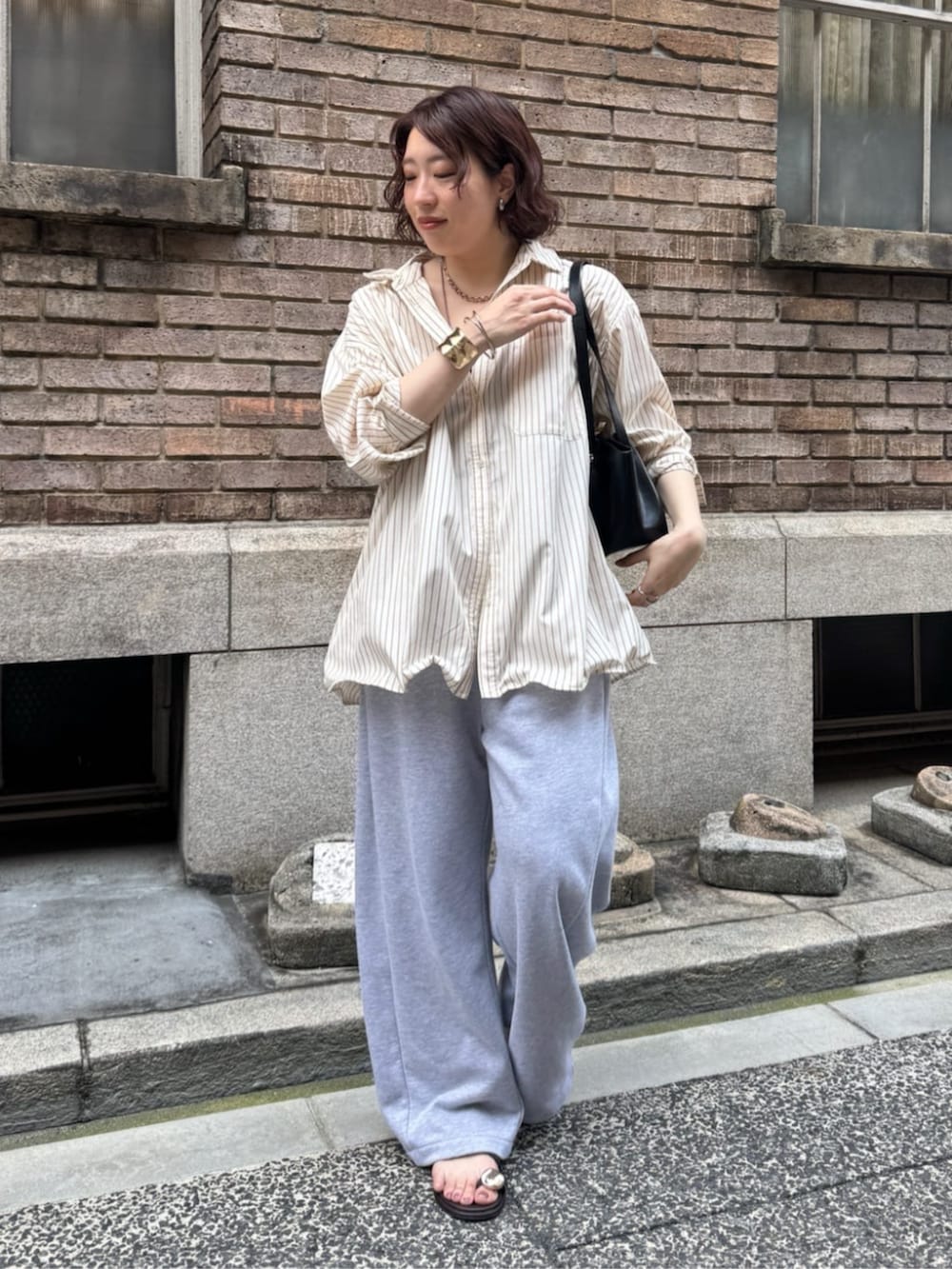 ブラック系のショルダーバッグ、グレー系のスウェットパンツ、ブラウン系のサンダルを着用したレディースの夏コーディネートの8枚目の写真