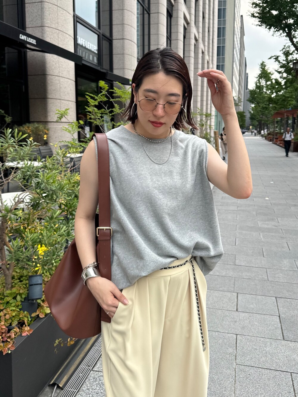 イエロー系のスラックス、グレー系のスウェット、シルバー系のベルトを着用したレディースの夏コーディネートの7枚目の写真