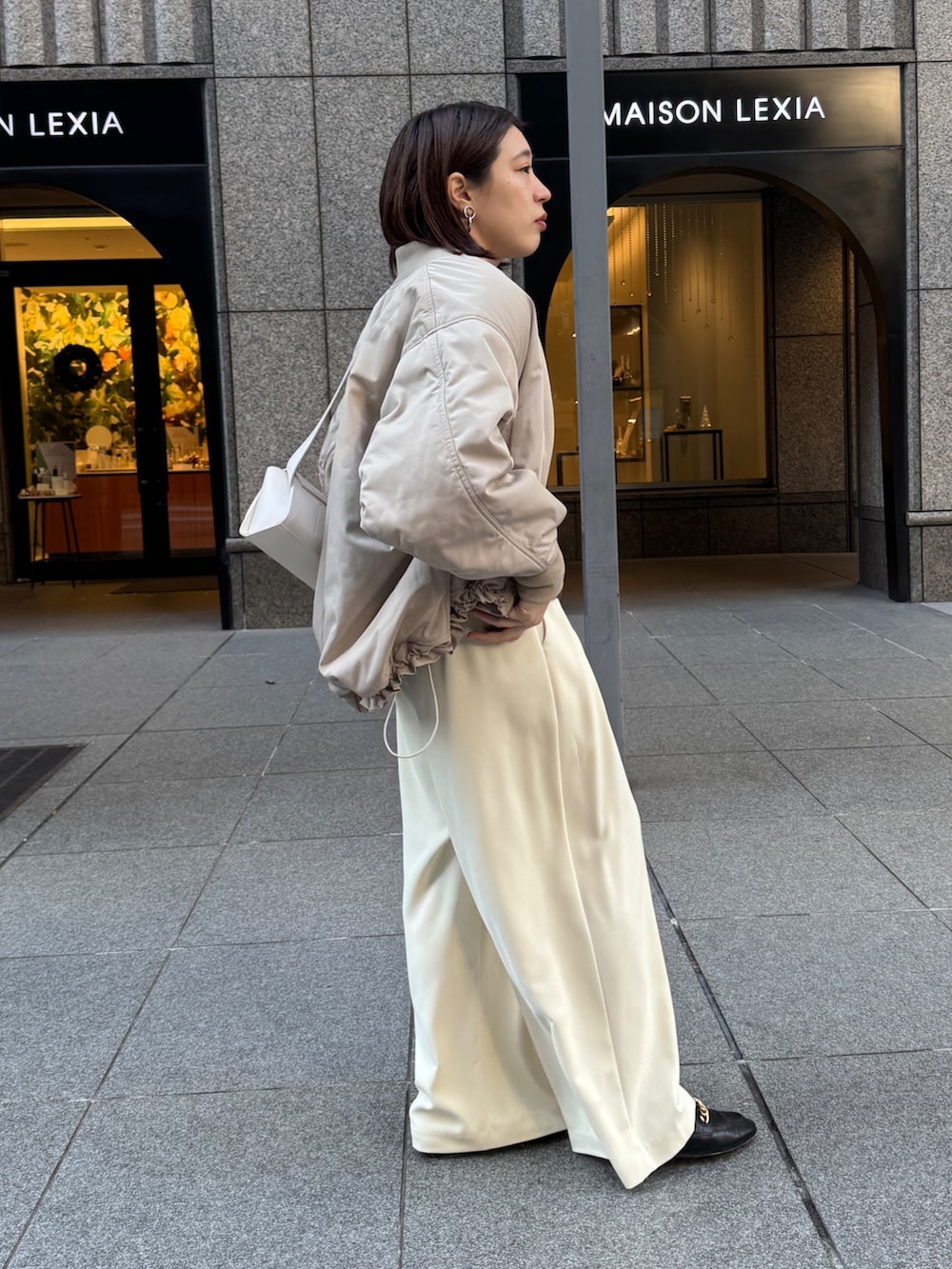 イエロー系のスラックス、ベージュ系のMA-1、ブラウン系のニット/セーターを着用したレディースの秋コーディネートの5枚目の写真