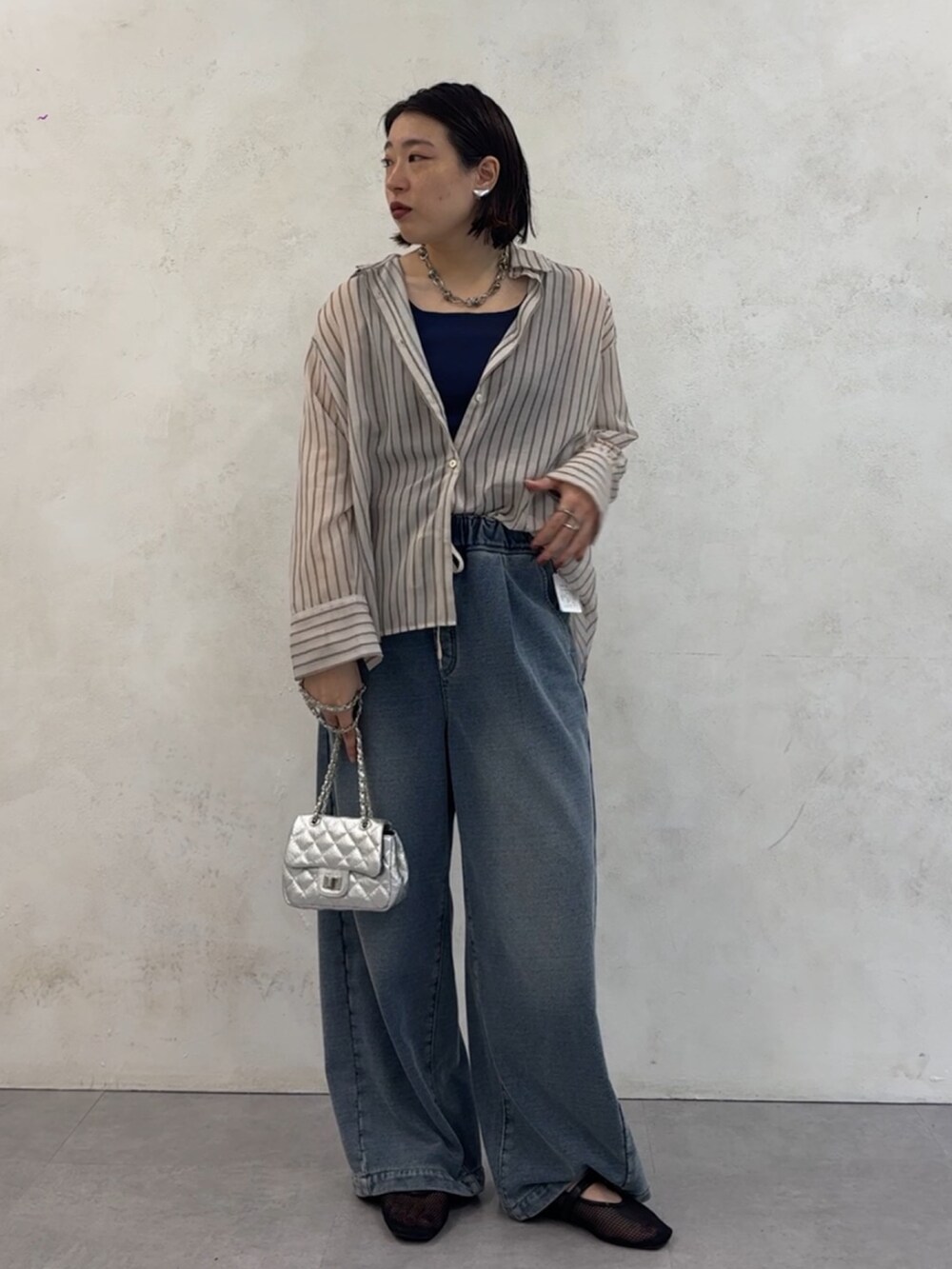 ブルー系のその他パンツ、ホワイト系のシャツ/ブラウス、シルバー系のショルダーバッグを着用したレディースの夏コーディネートの2枚目の写真