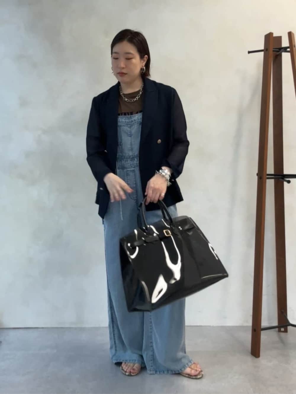 ブルー系のテーラードジャケット、ブラック系のショルダーバッグ、ブルー系のつなぎ/オールインワンを着用したレディースの夏コーディネートの3枚目の写真