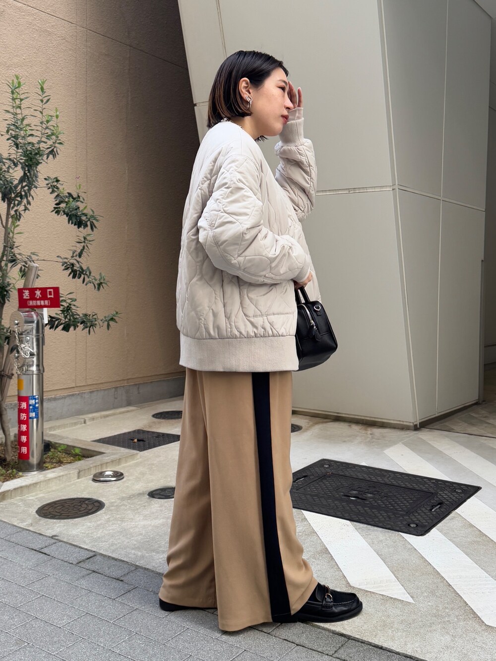 ベージュ系のその他パンツ、ホワイト系のその他アウター、オレンジ系のニット/セーターを着用したレディースの冬コーディネートの3枚目の写真