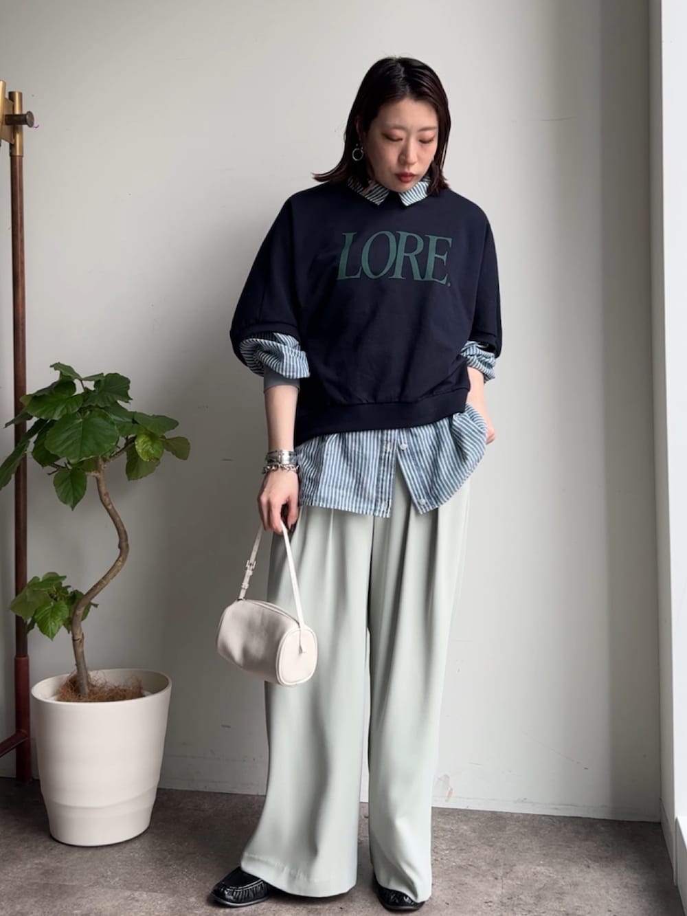 グリーン系のスラックス、ブルー系のシャツ/ブラウス、ブルー系のTシャツ/カットソーを着用したレディースの春コーディネートの2枚目の写真