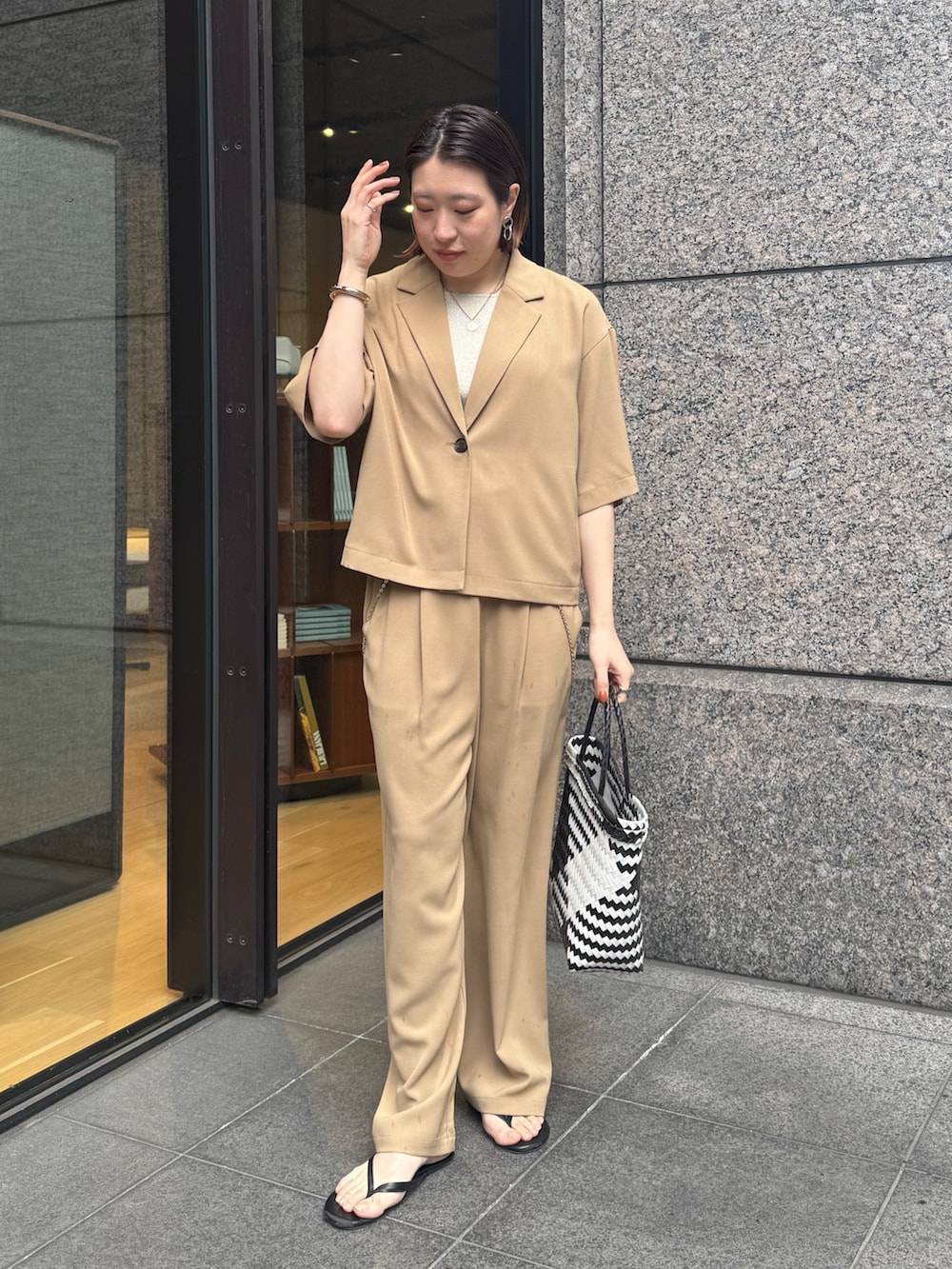 ベージュ系のニット/セーター、ベージュ系のその他パンツ、ベージュ系のテーラードジャケットを着用したレディースの春コーディネートの3枚目の写真