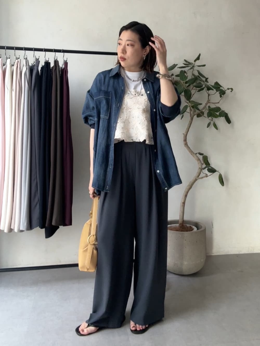 グレー系のスラックス、ブルー系のシャツ/ブラウス、ホワイト系のシャツ/ブラウスを着用したレディースの春コーディネートの2枚目の写真