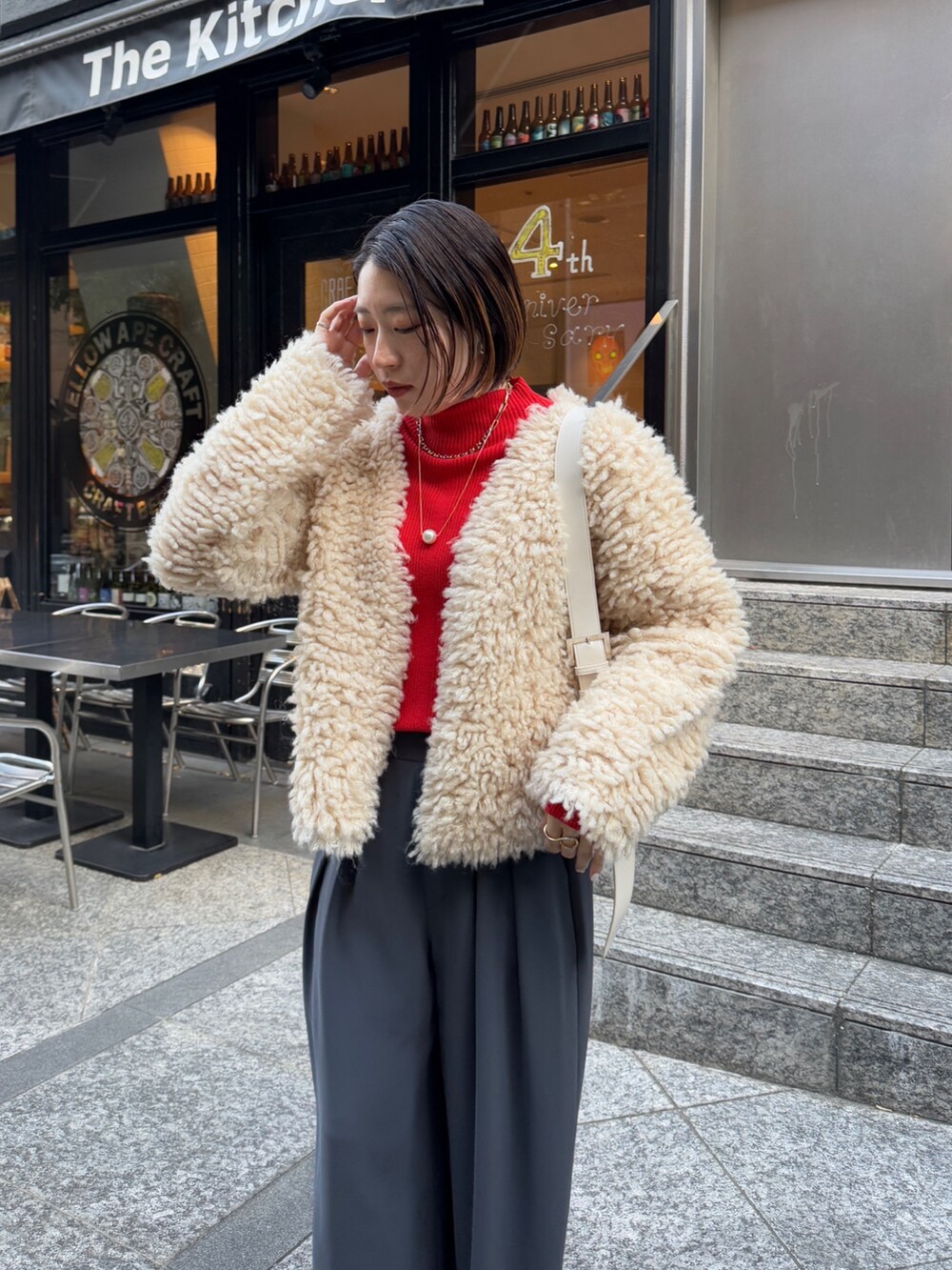 グレー系のスラックス、ホワイト系のショルダーバッグ、ベージュ系のカーディガン/ボレロを着用したレディースの冬コーディネートの6枚目の写真