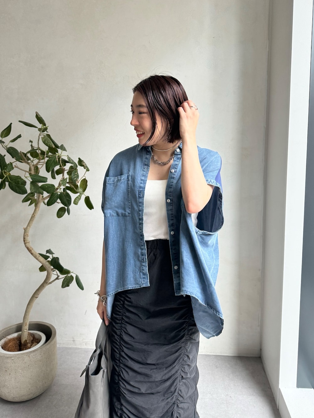 ブルー系のシャツ/ブラウス、ブラック系のスカートを着用したレディースの夏コーディネートの8枚目の写真