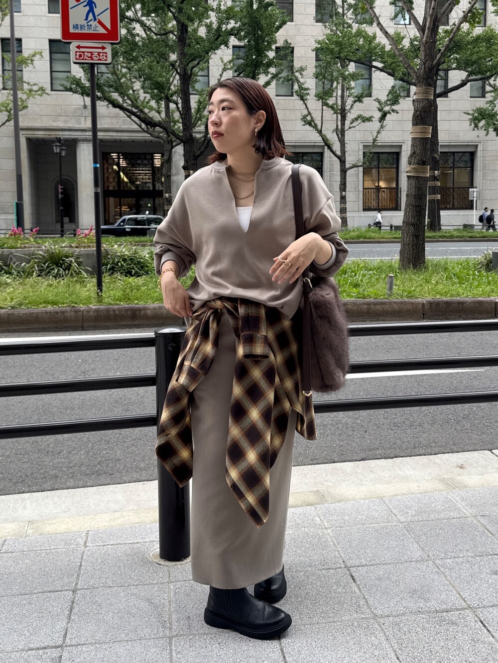 ベージュ系のTシャツ/カットソー、ベージュ系のスカート、ブラウン系のショルダーバッグを着用したレディースの秋コーディネートの6枚目の写真