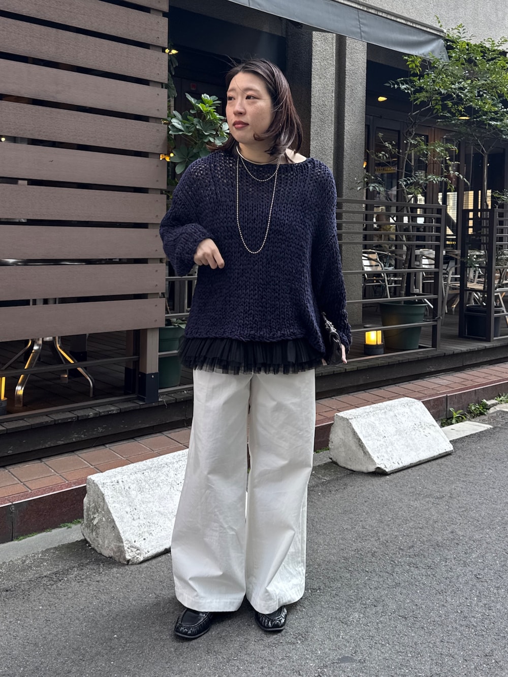 ブルー系のニット/セーター、ブラック系のシャツ/ブラウス、ホワイト系のその他パンツを着用したレディースの春コーディネートの2枚目の写真