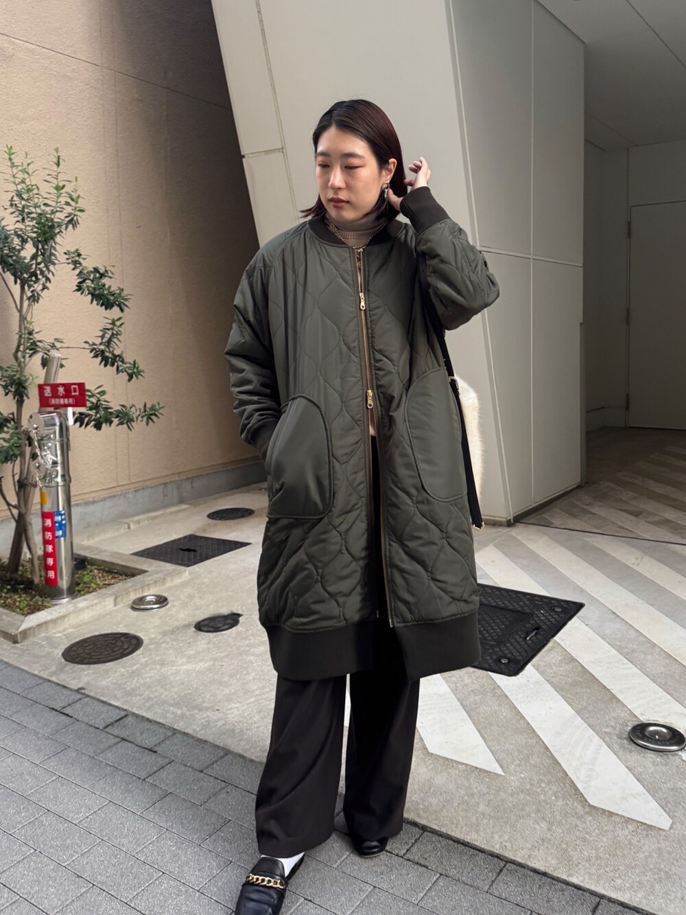 グリーン系のその他アウター、ベージュ系のニット/セーター、ブラウン系のその他パンツを着用したレディースの冬コーディネートの4枚目の写真