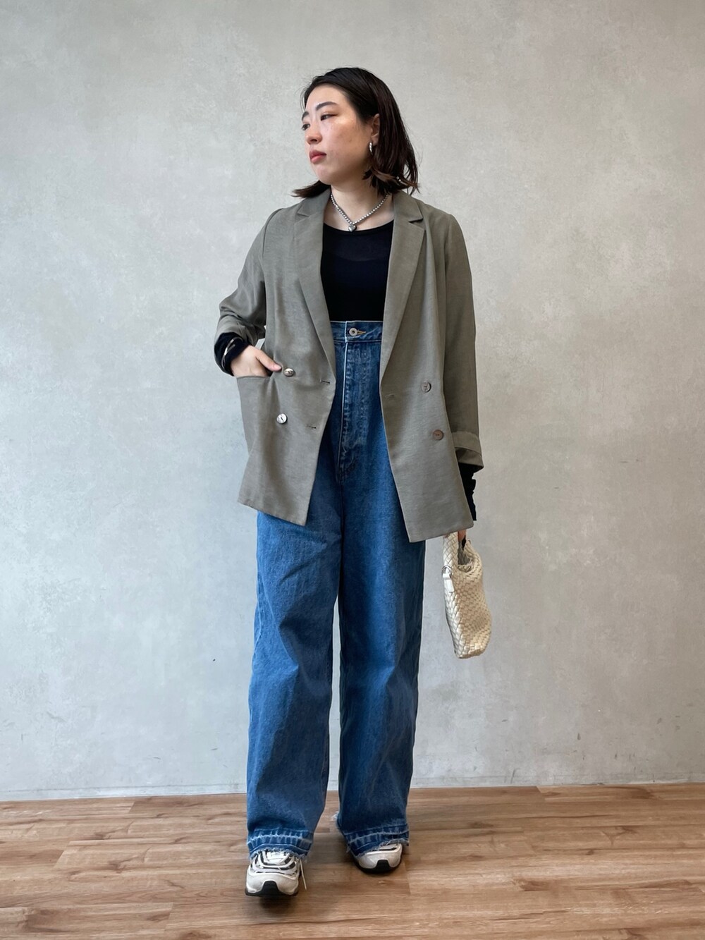 ブルー系のサロペット/オーバーオール、ベージュ系のテーラードジャケット、ブルー系のTシャツ/カットソーを着用したレディースの春コーディネートの4枚目の写真
