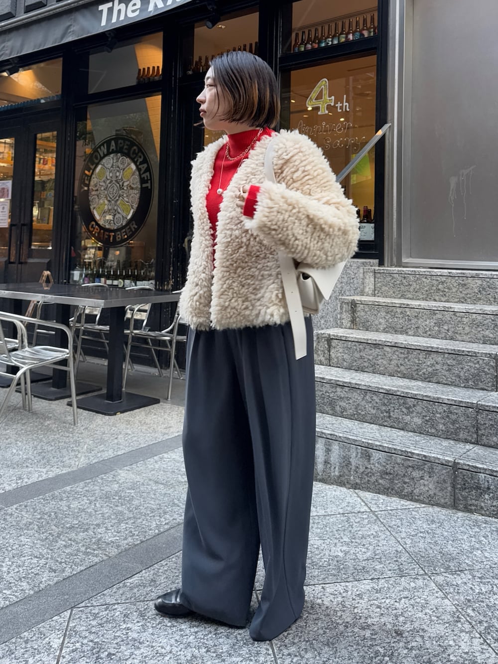 グレー系のスラックス、ホワイト系のショルダーバッグ、ベージュ系のカーディガン/ボレロを着用したレディースの冬コーディネートの3枚目の写真